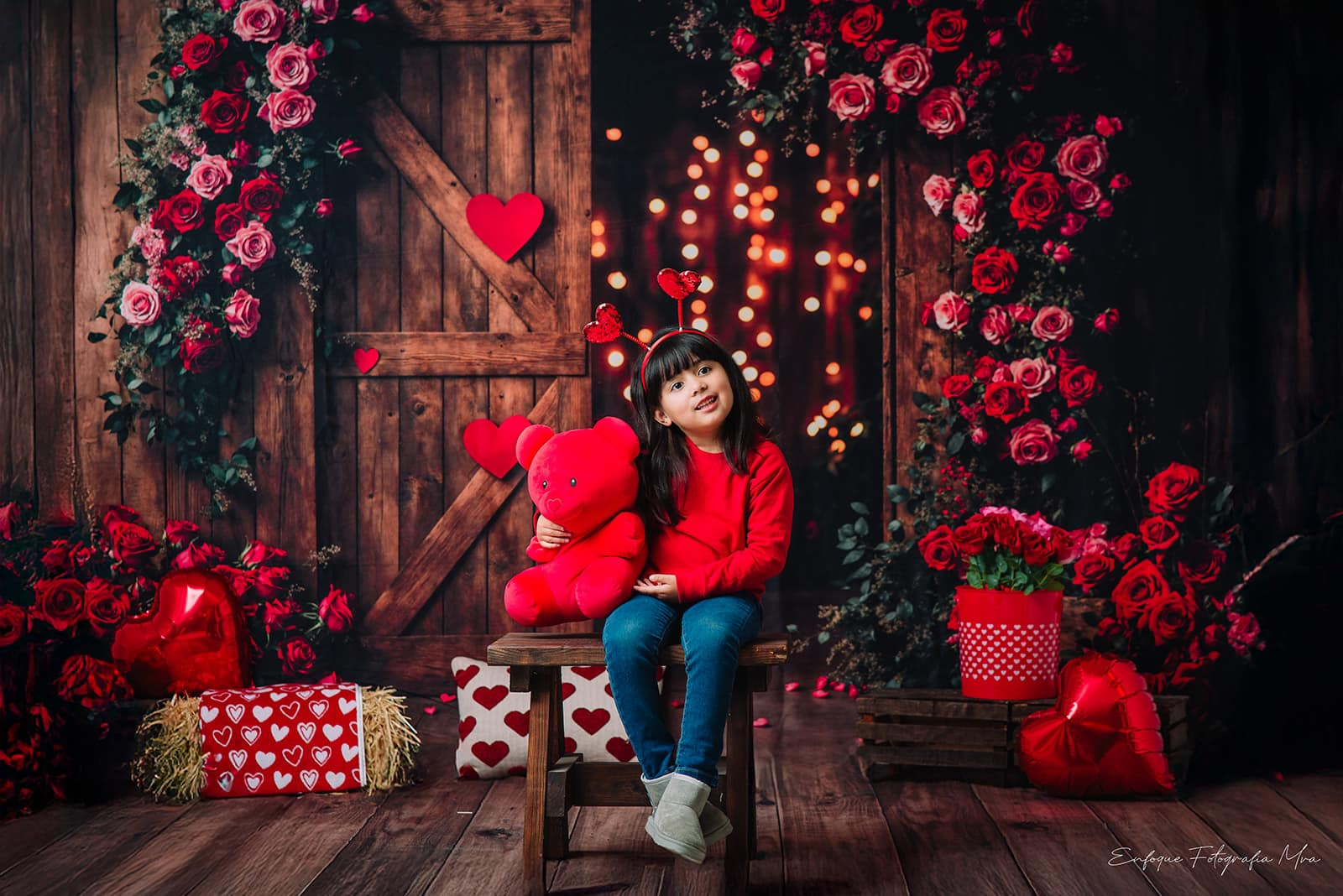 Girl smelling flowers standing in front of Valentine's Day backdrop