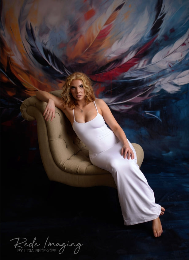 Woman in white dress sitting on sofa in front of Kate Sweep Colorful Graffiti Feather Backdrop