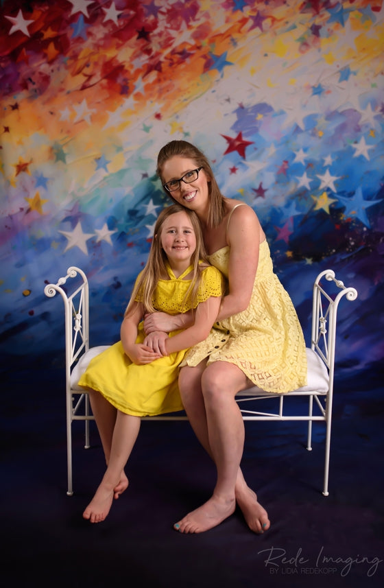 Mommy and me sitting in front of the Painted Rainbow Star Backdrop