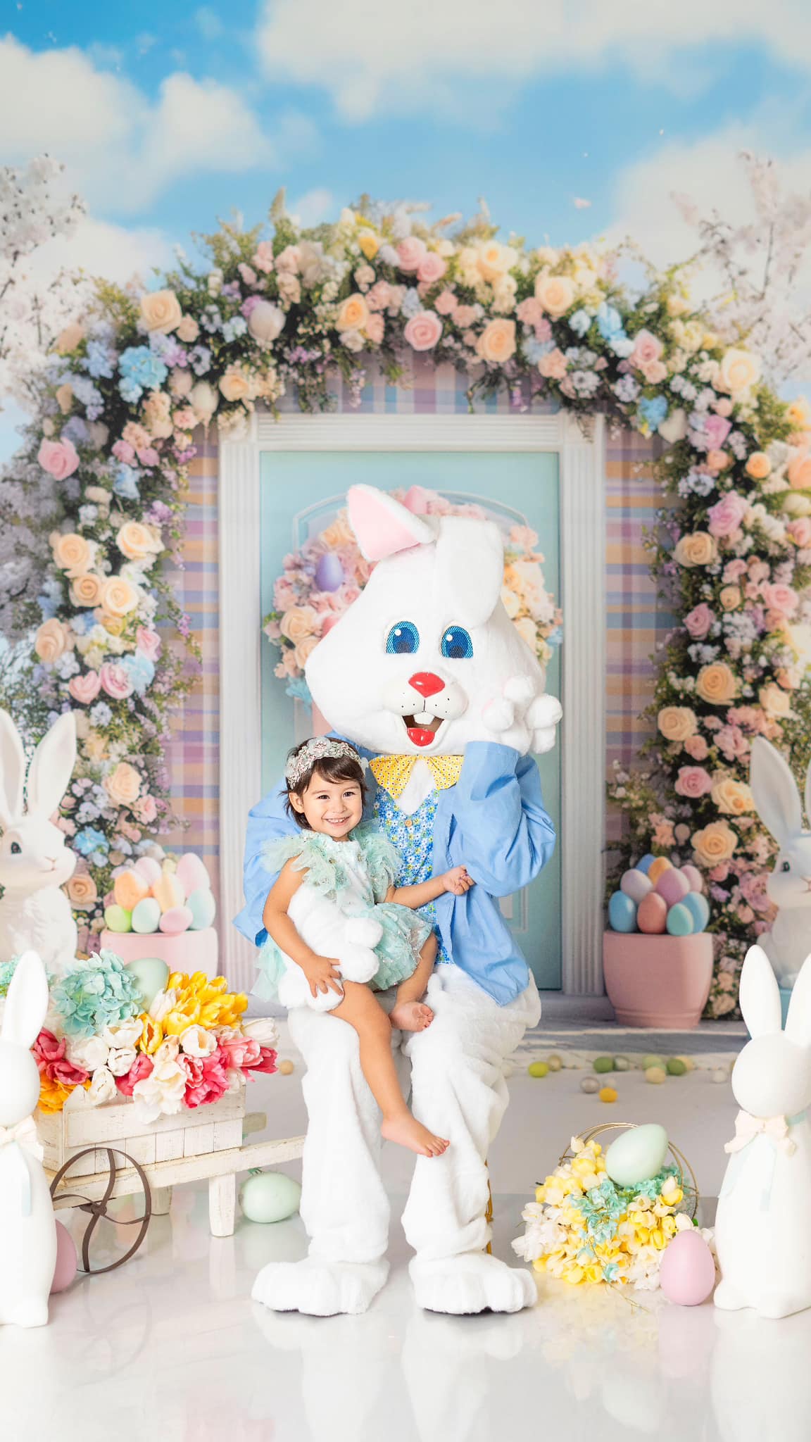 Kate Easter Outdoor Bunny Flower Arch Backdrop with floral garland, pastel decorations and Easter eggs under spring sky