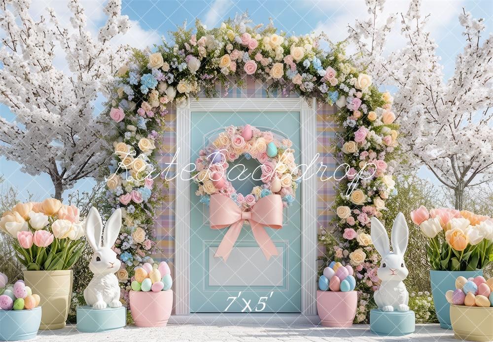 Easter bunny flower arch backdrop with pastel door, floral wreath, and spring decorations featuring white bunnies and eggs