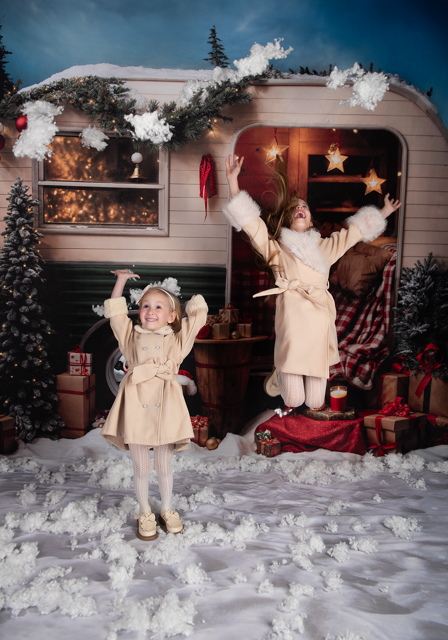 Two daughters jumping for joy in front of a green camper van backdrop