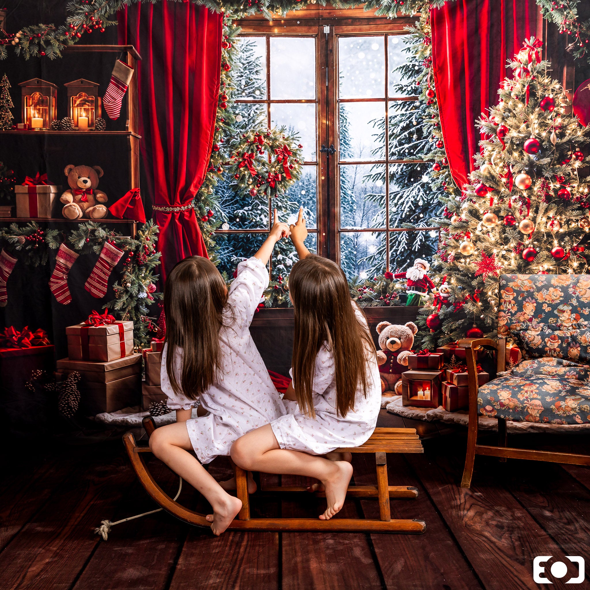 Two girls sitting in front of the window of Winter Christmas Red Curtain Backdrop looking at the snow scene